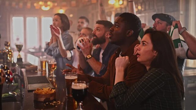 Diverse friends celebrating goal in sports bar watching soccer game