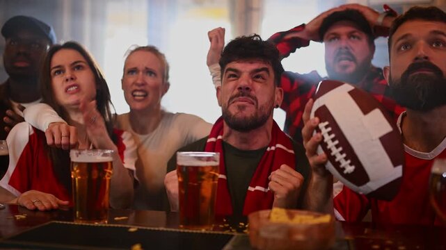 Disappointed american football fans watching a match in a bar