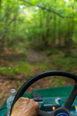Driver's View From Tractor Steering Through Lush Green Forest Trail