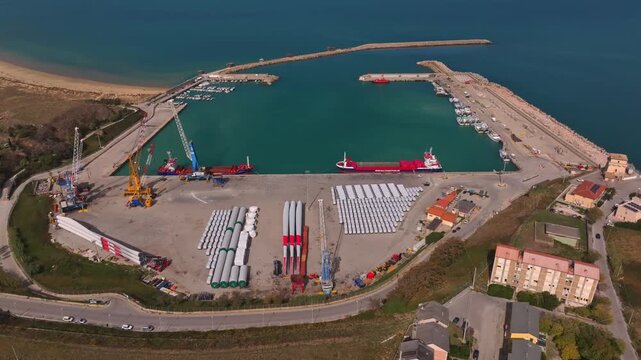 Industrial port footage from above showing cargo ships, small boats and logistics areas in Vasto, surrounded by coastline and open land.