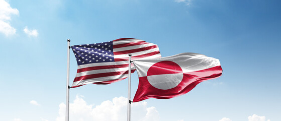 USA and Greenland flags Flying Together Against Blue Sky