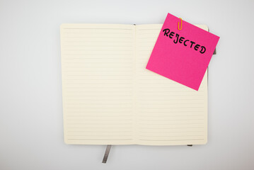 Rejected note with USB drive clipped on red paper and notebook.