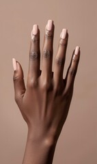 Closeup of dark skinned hand with nude manicure