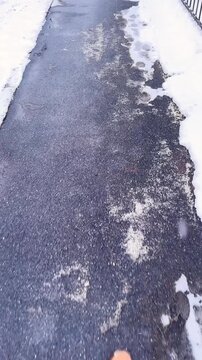 Deicing chemicals on pavement in winter. Salt grains on icy sidewalk, paving slab with rock salt in cold season. Slippery road sprinkled with technical salt and calcium. Prevent slipping concept