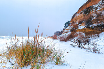 A snow-covered landscape with a clay cliff on the shore of the Sea of Azov.