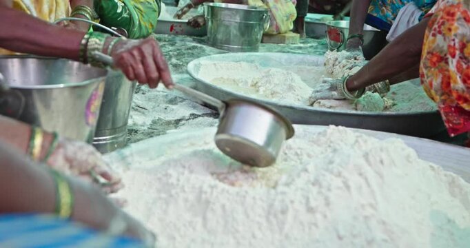 Indian Village Women And Men Preparing Mahaprasad Roti for a Spiritual Mass Gathering
