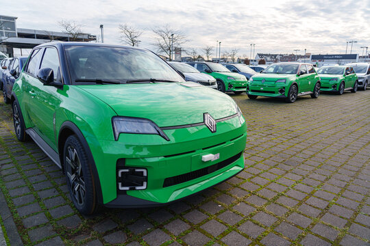 Green new Renault 5 electric cars parked at a dealership lot in Dusseldorf