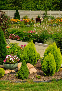 piękny ogr&oacute;d, zielony trawnik w ogrodzie otoczony krzewami ozodbnymi i kolorowymi kwiatami, chodnik w ogrodzie, kompozycja rabatowa, iglaki w ogrodzie, beautiful garden, designer garden, lawn