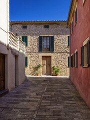 Traditional stone house facade with green shutters in the historic center of Alcudia