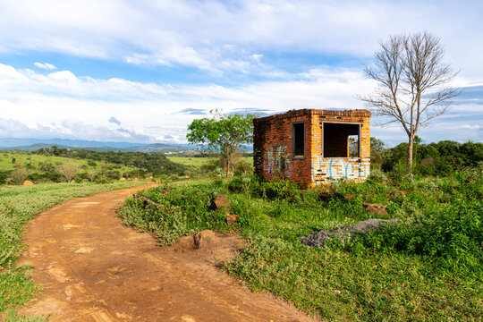 Abandoned building, covered in graffiti, on the edge of a dirt road