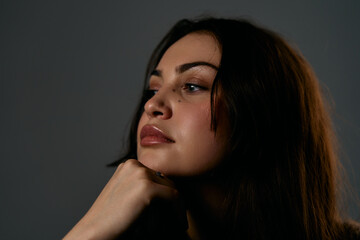Fototapeta premium Contemplative Beauty Portrait Of A Brunette Woman With Moody Studio Lighting And Soft Glow