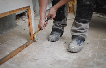 One young man is pulling out nails with a crowbar.
