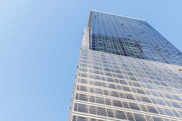 Modern glass skyscrapers photographed from a low angle against a clear blue sky.