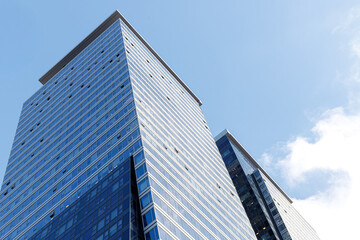 Fototapeta premium Modern glass skyscrapers photographed from a low angle against a clear blue sky.