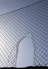 Looking up at a chain link fence with blue sky and clouds. wire fence. Chain link fence see sky....