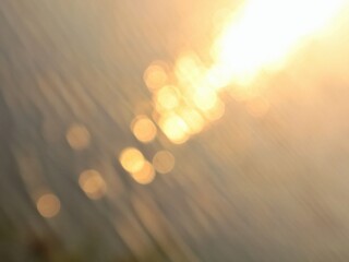 Golden sunset bokeh reflection on water surface. Dreamy bokeh lights of sunset shimmering on...