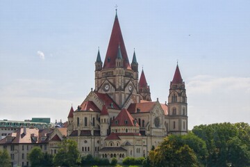 Fototapeta premium The historic Church of St. Francis of Assisi (Mexikokirche) with red tiled roofs against blue sky
