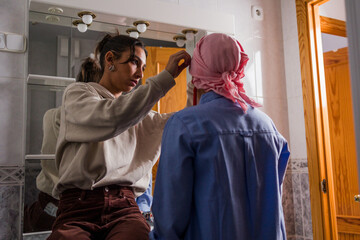 Daughter helping mother with cancer get ready