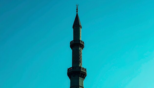 A minaret of a mosque against a clear blue sky, a symbol of Islamic architecture and spiritual places
