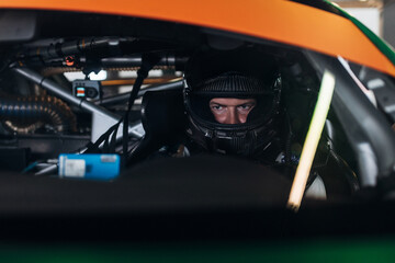 Racing Driver in Carbon Fiber Helmet Sitting Inside Race Car Cockpit During Track Day