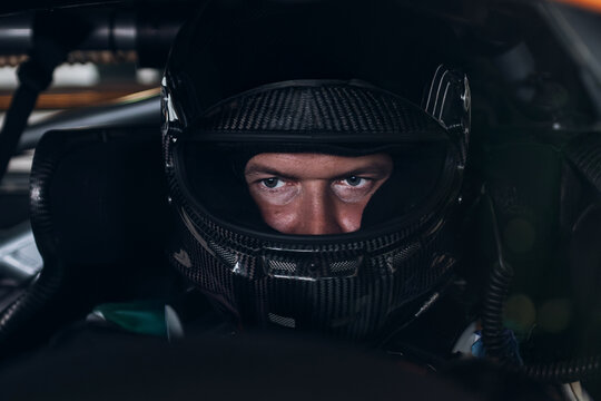 Racing Driver in Carbon Fiber Helmet Sitting Inside Race Car Cockpit During Track Day