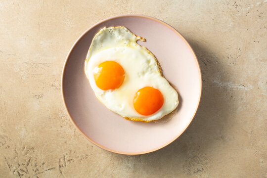 A top down view of a plate of fried orange yolk eggs.