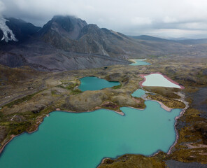 Aerial Drone View hike the seven 7 lakes of Ausangate cusco, Peru clouddy day green water mountains © Camilo