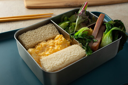 A view of a bento box, featuring egg sando.