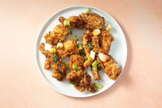 A top down view of a plate of fried frog legs.