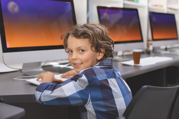 All-in-one computers are sitting in row in computer lab with orange-purple screens, paper cup
