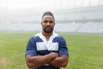 Blue-and-white rugby jersey is lying on grass pitch with painted markings and foggy stands