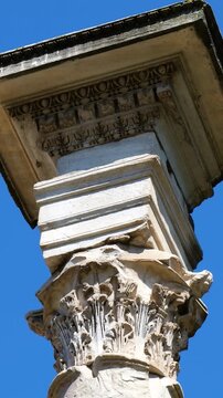 weathered roman marble column ornate corinthian capital against vivid blue sky domed brick church rises tempio del divo romolo up close view rome italy empire emperor 