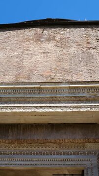 ancient roman brick rotunda facade richly carved marble entablature purple stone columns ivy covered masonry defines tempio del divo romolo reveals upward view rome italy empire 