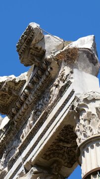 ancient roman triumphal arch fragment corinthian columns ornate reliefs broken stonework contrasts vivid blue sky foro di cesare reveals angle upward view rome italy empire emperor 