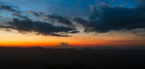 silhouettes mountains with orange and yellow sky in sunset time