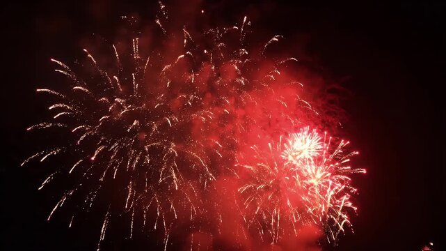 Chinese New Year firecracker display exploding with vibrant red and gold pyrotechnics lighting night sky