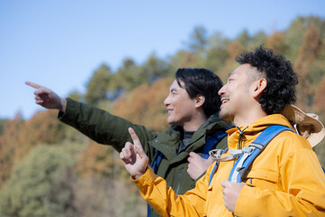 登山をする旅行客のイメージの横顔　指差しで登頂を目指すクローズアップ(多摩木材センター協同組合プロパティ許可ずみ）