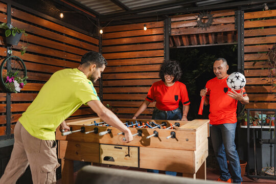 devoted supporter cheering with a soccer ball during an intense foosball game