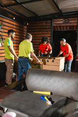 Diverse group of friends from different generations playing a lively game of foosball