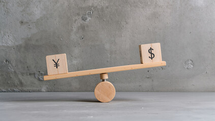 コンクリート壁の前で円とドルの積み木を載せた木製シーソーを比較に使う