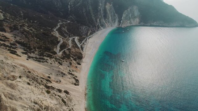 Aerial view of long beach Myrtos and turquoise sea by mountain slopes Kefalonia