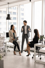 Young 25s Arabian project leader in elegant suit, conduct meeting with two women colleagues,...