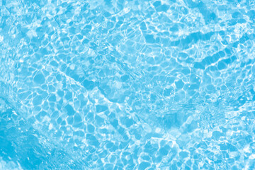 Obraz premium Blue water with ripples on the surface. Defocus blurred transparent blue colored clear calm water surface texture with splashes and bubbles. Water waves with shining pattern texture background.