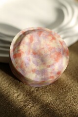 Artistic Soap Bar with Pastel Swirls on Sand, Ideal for Spa Product Mockups and Creative Projects.