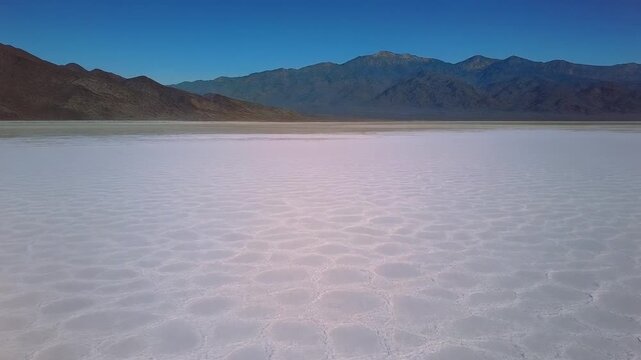 Panoramic shot of the Badwater Basin salt flats with mountains in Death Valley