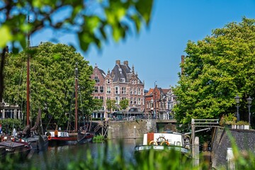 Obraz premium Discover Rotterdam s charming canals lined with historic architecture and classic boats. A picturesque scene in Rotterdam, Netherlands, perfect for tourism and showcasing Dutch culture.