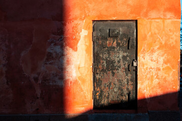 Old black door and red wall.