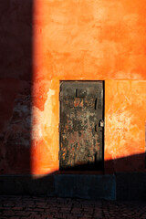 Old black door and red wall.