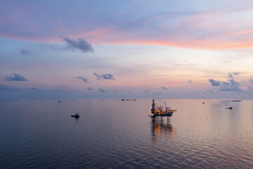 Aerial view from a drone of big jack up offshore drilling oil rig, production platform and supply...