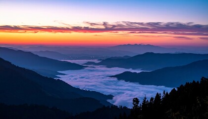 Obraz premium Mountain panorama at sunrise with layered ridges, valley fog, and colorful sky